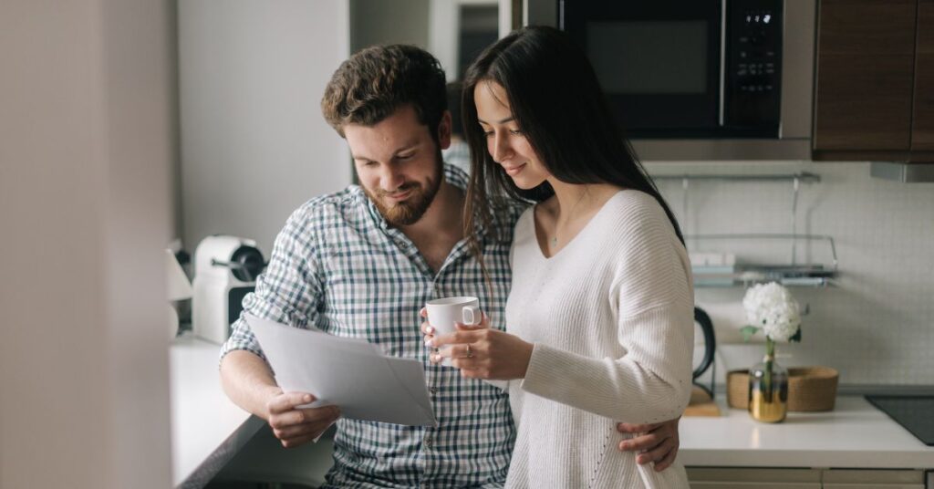 couple in The Hills District planning their mortgage payoff strategy with financial documents and calculators. GT Financial Services - Your mortgage broker for faster mortgage payoff in The Hills District.